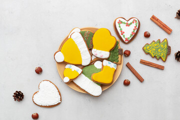 Christmas gingerbread cookies in a plate on a light background. Cinnamon sticks, pine cones and...