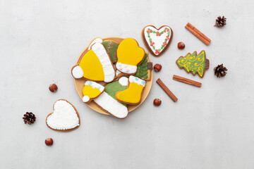 Christmas gingerbread cookies in a plate on a light background. Cinnamon sticks, pine cones and...