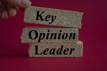 KOL key opinion leader symbol. Concept words KOL key opinion leader on brick blocks. Beautiful red...