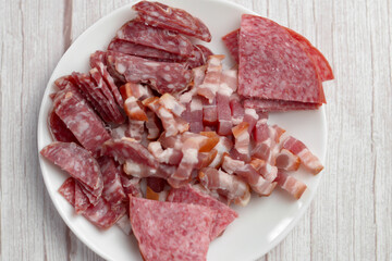 Sliced salami and chopped bacon ready for cooking.