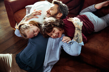 Happy siblings having fun with father at home