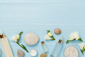 Flat lay with spa products and flowers on wooden background