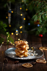 Belgian waffles with pine tree on background with Christmas light 