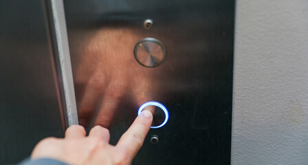 hand pressing elevator button, symbolizing choice and progress