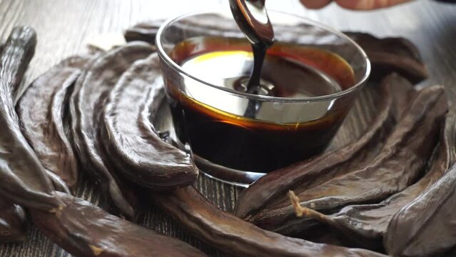 Close-up of carob molasses being eaten with a spoon on a plate,
