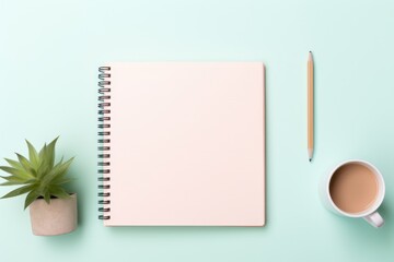 top view of a clean workspace featuring a pink blank notebook mockup, a wooden pencil, a cup of coffee, and a potted succulent on a light aqua background