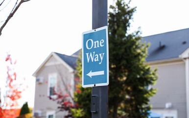 One-way arrow, urban symbol of directional flow and traffic control, against cityscape backdrop