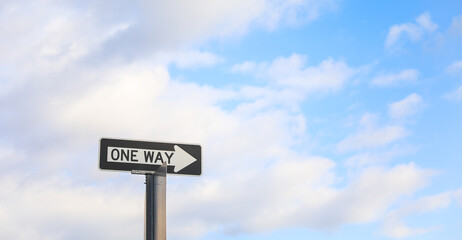 One-way arrow, urban symbol of directional flow and traffic control, against cityscape backdrop