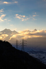 pylons of a high voltage line above the Rhône plain in Switzerland in winter - 693665571