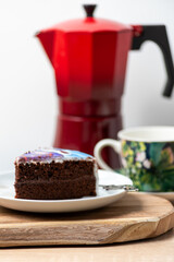 cup of coffee with red coffee pot and cake on a black background 