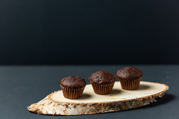 Chocolate cupcakes, muffins arranged on a piece of wood