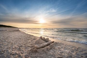 Zamek z piasku na plaży zachód słońca