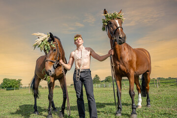 Jeune homme torse nu tenant deux chevaux couvert de fleurs - obrazy, fototapety, plakaty