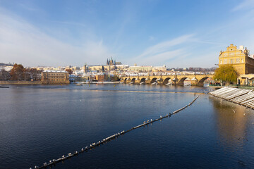 Snowy Prague Lesser Town with Prague Castle and Charles Bridge above River Vltava in the sunny Day...
