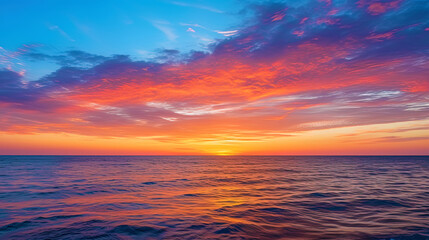Obraz premium The sunrise over the ocean, painting the sky in shades of orange and blue