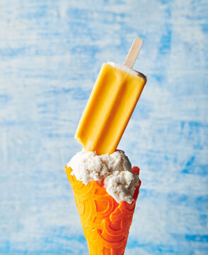 Ice cream with orange creamsicle with an orange cone