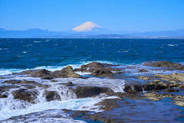 藤沢市江の島の稚児ヶ淵の岩に打ち寄せる波と富士山を見る