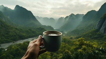 Poster A hand extends with a cup of coffee, overlooking a lush valley with mist-veiled mountains, capturing the essence of a serene morning retreat... © Iona