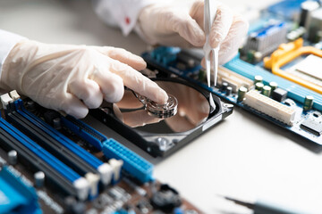 person in gloves work in laboratory, repair broken hdd hard drive