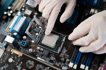 hand insert processor cpu chip in the socket of motherboard, computer assembly process
