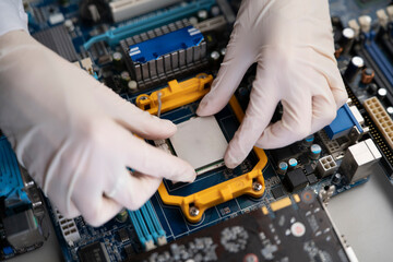 hand insert processor cpu chip in the socket of motherboard, computer assembly process