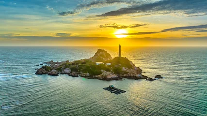 Tuinposter Ke Ga lighthouse is located on an island near the shore seen from above, this is an ancient lighthouse built in the French period to guide the water in the central waters of Vietnam. © huythoai