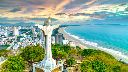 Aerial view of coastal Vung Tau city, Vietnam in the morning. The place where there is a statue of Christ on the mountain protects Vung Tau Peninsula's peace. - obrazy, fototapety, plakaty