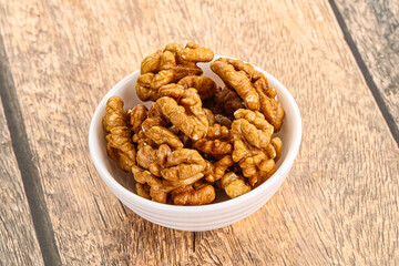 Fototapeta premium Cracked unshelled walnut in the bowl