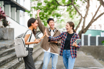 Group of young interracial diverse university students chatting together outside, engaging in a discussion together, college campus, enjoying campus recreation. Happy friends