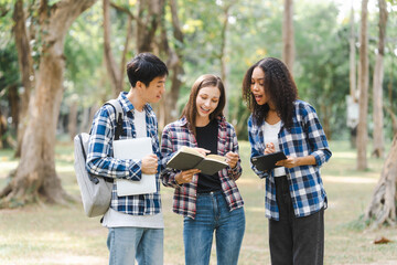 Group of young interracial diverse university students chatting together outside, engaging in a discussion together, college campus, enjoying campus recreation. Happy friends