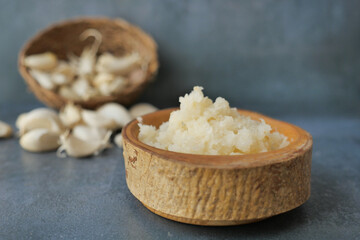 close up of minced garlic on a wooden spoon 
