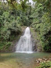 A natural waterfall located in the middle of the forest with fresh water.