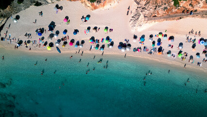 Aerial view of beach full of colorful umbrellas with tropical sea water
