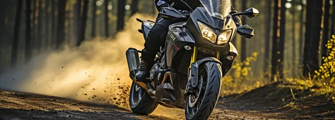 Crédence de cuisine en verre imprimé Moto Motorcyclist on a bespoke, elegant motorcycle on an asphalt road in a forest, wearing motorcycle apparel and a helmet.