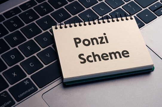 There is notebook with the word Ponzi Scheme. It is as an eye-catching image.