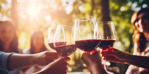 Schilderijen op glas Blurred image of friends toasting wine in a vineyard in the daytime outdoors. Happy friends having fun outdoors. © kimly