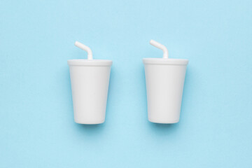 Two large white drinks glasses on a blue background.