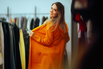 Beautiful Woman Trying on a Mustard yellow Cardigan. Fashionable girl wearing a cool new sweater
