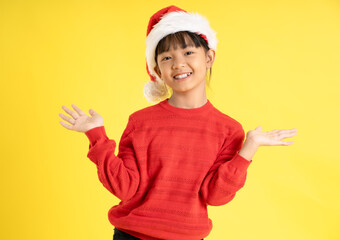 Image of an Asian girl wearing a Christmas sweater and hat posing on a yellow background
