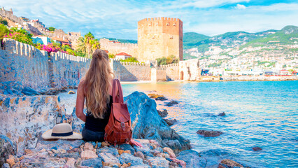 Fototapeta premium Woman travelling in Turkey, Alanya city and red tower