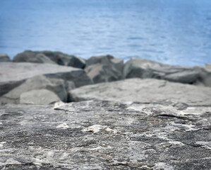 Empty stone base, empty flat stone on the background of the sea, rocky shore Background. Natural background. The backdrop. Space for text. Place for the product. Copy space