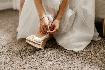 Bride getting ready putting on wedding shoes