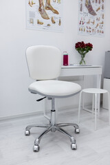 A white staff chair at the table in the pedicure room
