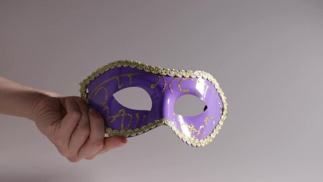 Carnival mask in hand, a vintage and theatrical piece for a circus party