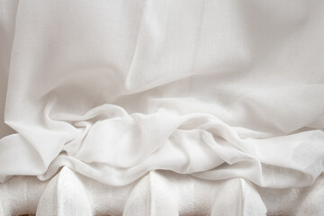 White drapes resting on a metal heater, abstract textures backdrop