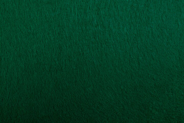 Felt fabric texture with visible fiber, dark green color abstract pattern backdrop, close up