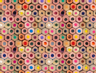 Fototapeta premium Multiple colored wooden crayons bottom arranged in seamless pattern, abstract backdrop, soft focus close up