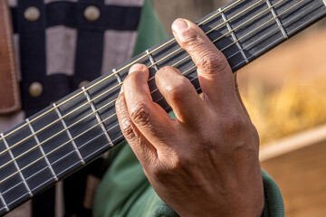 A guitarist's hand makes a chord