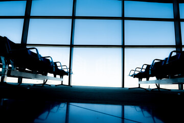 Silhouette airport waiting seats and window with blue sky