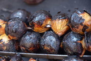 vegetables grilling on charcoal with onion and tomato with fire and smoke